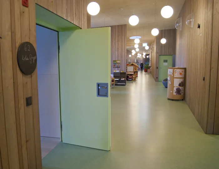 Heller Flur in einer Kindertagesstätte mit offenem Gruppenraum und Spielbereich