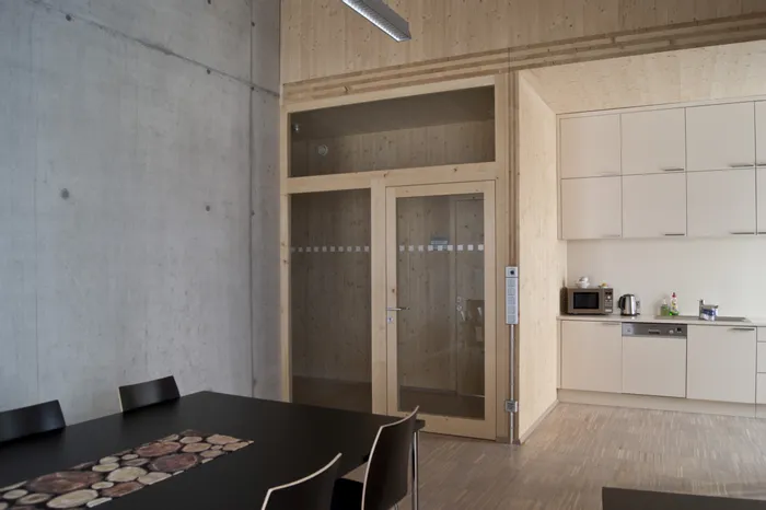 Moderne Büroküche mit Holzwänden, Einbauküche und Glastür zum Besprechungsraum