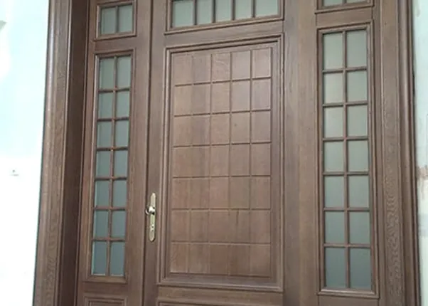 Massive Holzeingangstür mit Glaseinsätzen und dekorativem Türrahmen