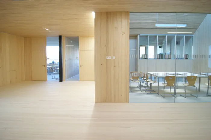 Modernes Büro mit Holzverkleidung, Glastrennwand und Konferenztisch mit Holzstühlen
