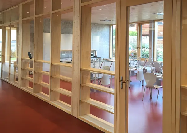 Moderne Schulküche mit Glastüren und offenen Holzregalen in heller Innenarchitektur