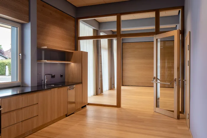 Moderne Küche mit Holzfronten, Einbauspüle, Glastür und viel Tageslicht
