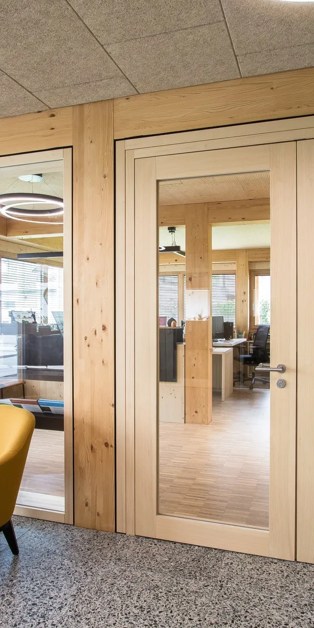 Moderne Wartezone mit gelben Sesseln vor dem Büro der Bezirksbauernkammer mit Glastüren