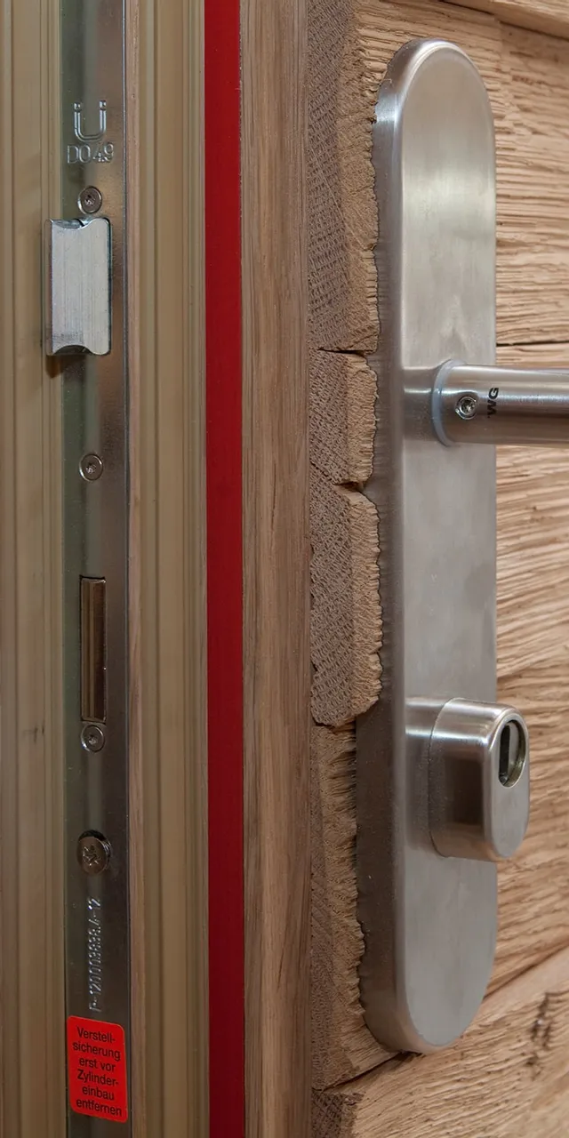 Massivholztür mit moderner Sicherheitsverriegelung und Edelstahlgriff in Schreinerei
