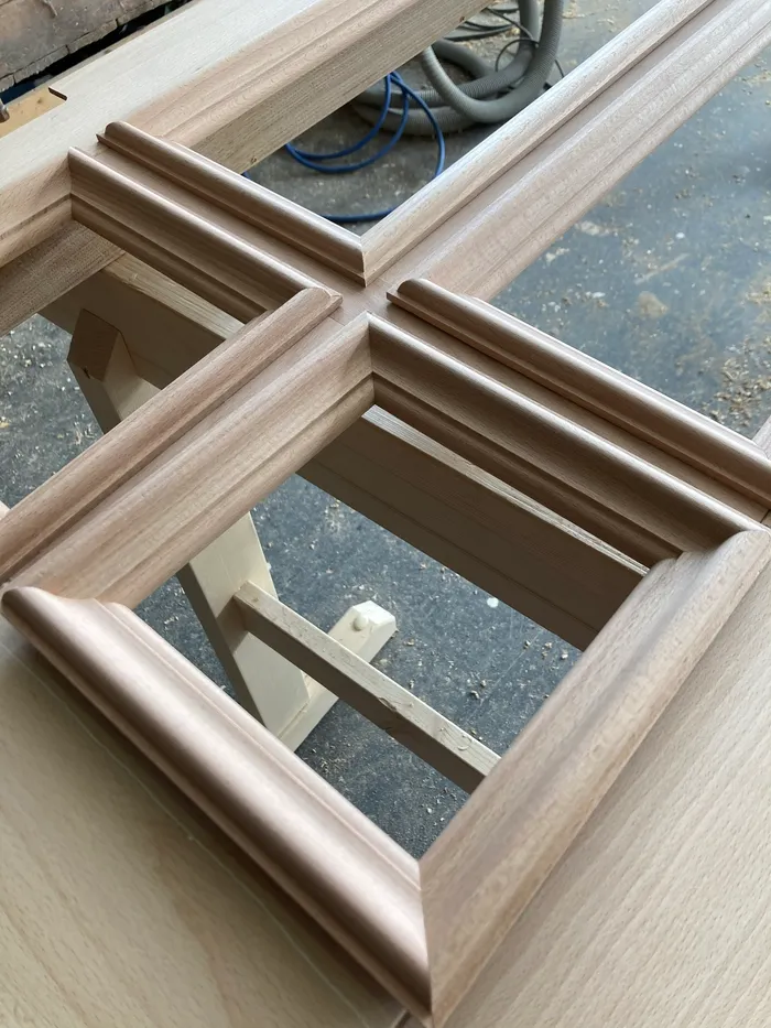Detail einer hölzernen Fensterrahmenkonstruktion mit Fräsprofilen in einer Werkstatt