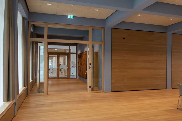 Moderner Flur mit Holzboden, Glastüren und minimalistischer Innenarchitektur