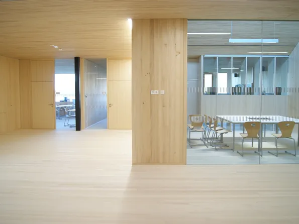 Modernes Büro mit Holzverkleidung, Glastrennwand und Konferenztisch mit Holzstühlen