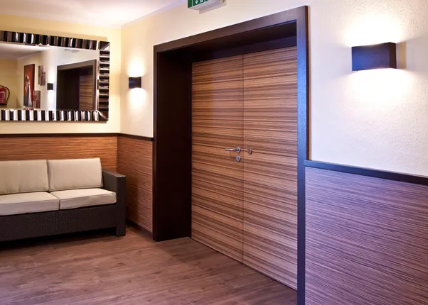 Modernes Hotelflur-Interieur mit Holztüren, Wandverkleidung und Sofa